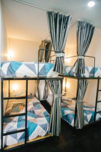a bunk bed room with two bunk beds with curtains at Thung Lũng Mơ - Dream Valley in Khu Chi Lăng