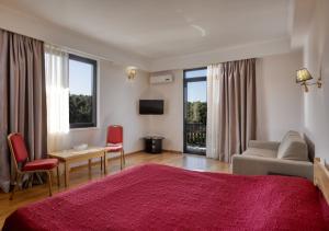 een slaapkamer met een rood bed en een woonkamer bij Hotel Apsara in Pitsoenda
