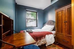 a bedroom with a bed with a desk and a window at Lamartine Chelsea in New York