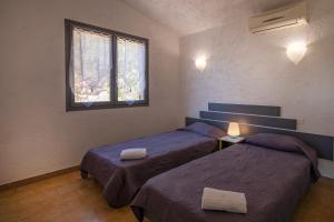 a bedroom with two beds and a window at Residence "U LATONU" in Porto-Vecchio +35 photos