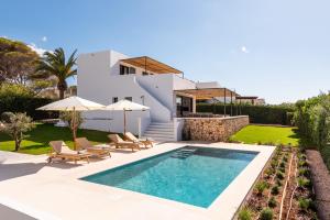 a villa with a swimming pool and a house at Villa Baixa - Es Canutells in Mahón