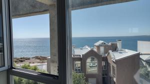 a view of the ocean from a window at Ayres del Sur in Puerto Madryn