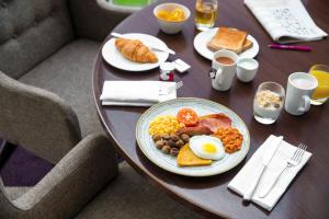 un tavolo con un piatto di prodotti per la colazione di Crowne Plaza Glasgow, an IHG Hotel a Glasgow