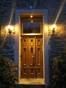 una porta in legno su una casa di mattoni con luci di Die Alte Schule app a Saint-Vith