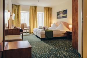a hotel room with a bed and a desk at Kulturhotel Fürst Pückler Park in Bad Muskau