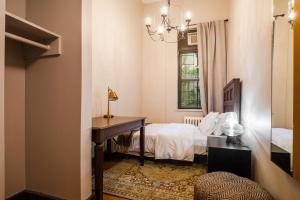 a bedroom with a bed and a desk and a window at Lamartine Chelsea in New York