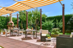un patio con mesas y sillas bajo una sombrilla en Green Paradise Holidays villa Apartment, en Massa Lubrense