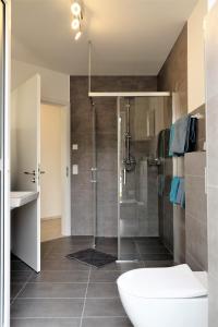 a bathroom with a shower with a tub and a sink at family + friends apartment ferienwohnung in Ransbach-Baumbach