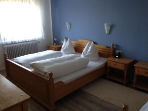 a bedroom with a bed with white sheets and pillows at Hotel und Restaurant -Gasthaus Zur Pfalz in Hockenheim +35 photos