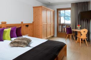 sypialnia z dużym łóżkiem i stołem z krzesłami w obiekcie Hotel Goldried w mieście Matrei in Osttirol +37 zdjęć
