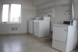 Cette chambre comprend plusieurs réfrigérateurs blancs et une fenêtre. dans l'établissement Recoleta Departamento, à Buenos Aires