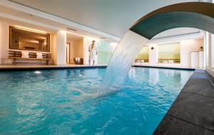 einen Pool mit einem Brunnen in einem Hotel in der Unterkunft Hotel Überbacher in Lajen