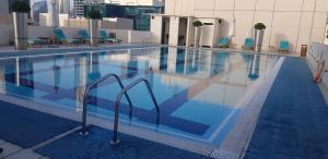 a swimming pool with a pool table and chairs at Bespoke Holiday Homes - Bay Square in Dubai