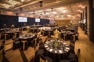 um salão de banquetes com mesas e cadeiras numa sala em Crowne Plaza Glasgow, an IHG Hotel em Glasgow