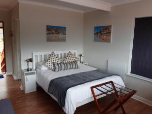 sypialnia z dużym białym łóżkiem z poduszkami w obiekcie A Place in Thyme w mieście Fish Hoek