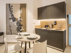 een keuken met een tafel en stoelen en een wastafel bij Mon Suites Benlliure in Valencia