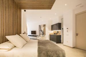 a bedroom with a large bed and a kitchen at Mon Suites Benlliure in Valencia