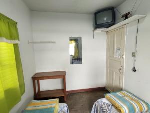 迪亞曼蒂納的住宿－Pousada Dona Dazinha，客房设有两张床和一台墙上的电视。