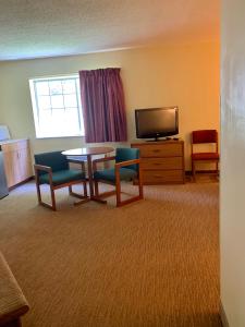 a room with a table and chairs and a television at Brookshire Inn in Inez