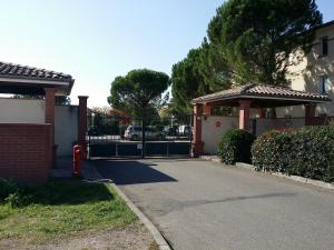 um portão para uma casa com um hidrante vermelho em Le Sporting Land - avec entrée autonome, parking privé & gourmandises offertes ! - em Gaillac