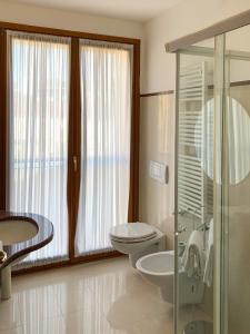 a bathroom with a toilet and a sink and a shower at Eurohotel Palace Maniago in Maniago