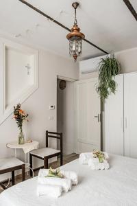 Habitación blanca con 2 camas y lámpara de araña. en Villa Curte Nicia, en Nizza Monferrato