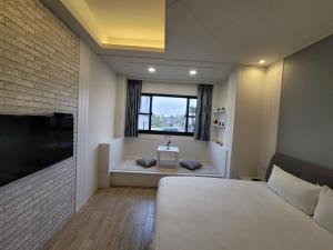 a bedroom with a large bed and a window at 渡小夜電梯民宿 Yilannight B&B in Wujie