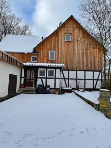 eine Scheune mit Schnee davor in der Unterkunft Ferienwohnung im Hooptal in Negenborn