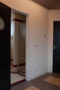 een badkamer met een glazen deur en een douche bij Studio aan Zee in Westkapelle