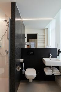 a bathroom with a white toilet and a sink at Alpha Hotel and Aparthotel in Tienen