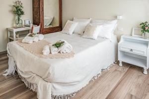 a bedroom with a bed with towels and a mirror at Villa Curte Nicia in Nizza Monferrato