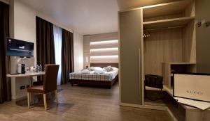 
a hotel room with a bed, desk and a television at Duomo Hotel & Apartments in Milan
