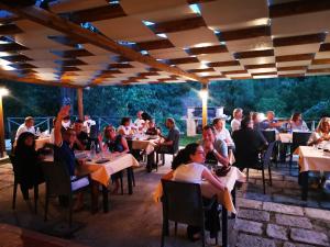 un grupo de personas sentadas en mesas en un restaurante en Agriturismo Podere S. Croce, en Saturnia