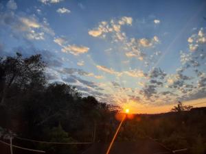 einen Sonnenuntergang mit der Sonne am Himmel in der Unterkunft Pousada Lua Cheia in Botucatu