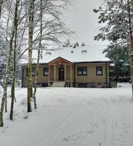a house with snow on the ground in front of it at Nadbużańska Przygoda in Janów Podlaski