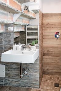 a bathroom with a white sink and a brick wall at Villa Curte Nicia in Nizza Monferrato