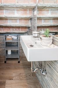 a bathroom with a white sink and a brick wall at Villa Curte Nicia in Nizza Monferrato