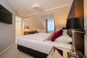 a bedroom with a large bed with a lamp at Landhotel Donner in Meschede +47 photos