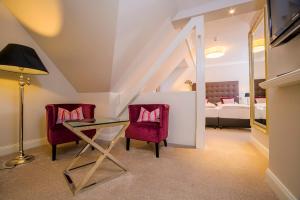 a living room with a glass table and two chairs at Landhotel Donner in Meschede