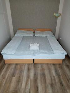 una cama con una almohada blanca encima en Apartman Pávai-Silye en Hajdúszoboszló