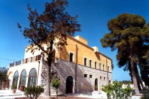 an old brick building with trees in front of it at Villa Carcano in Trani