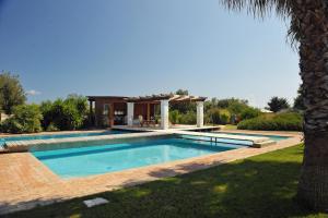 a swimming pool in a yard with a palm tree at Villa Carcano in Trani