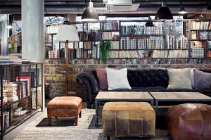 a living room with a couch and a book shelf at The Hoxton, Shoreditch in London