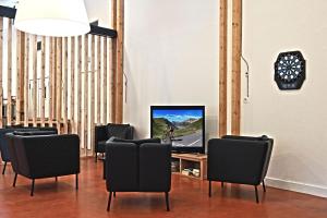 a room with chairs and a tv on a table at Hôtel Le Marintan in Saint-Michel-de-Maurienne
