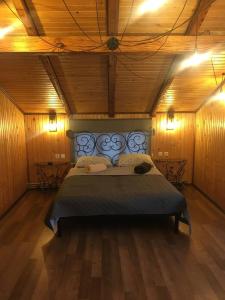 1 dormitorio con 1 cama grande en una habitación con paredes de madera en Файно Є en Mykulychyn