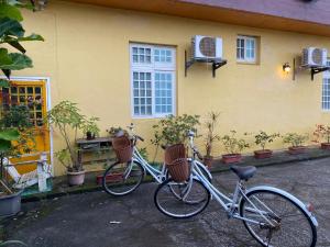 dos bicicletas estacionadas frente a una casa amarilla en Yilan Real Fun Homestay, en Dongshan