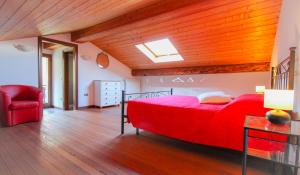 a bedroom with a red bed and a red chair at Da Anna in Cremia