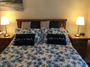 a bed with two pillows saying wife is a leader at B2 Waterfoot Apartment in Newcastle