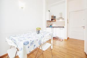 a white kitchen with a table and chairs at Cuore di Sanremo apartment and free parking in Sanremo