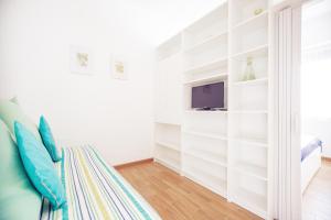 a white room with a bed and a tv at Cuore di Sanremo apartment and free parking in Sanremo